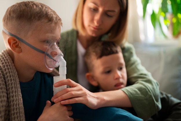 Photo side view sick kid using a nebulizer