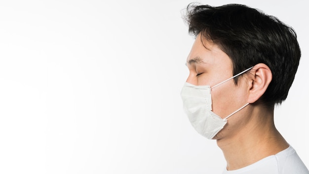 Photo side view of sick man wearing a medical mask