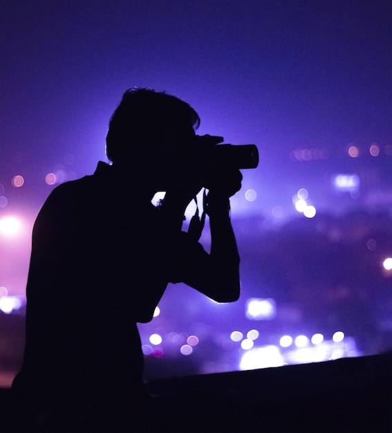 Photo side view of a silhouette male photographer