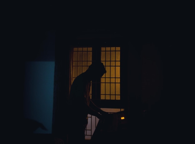 side view of silhouette man standing in darkroom