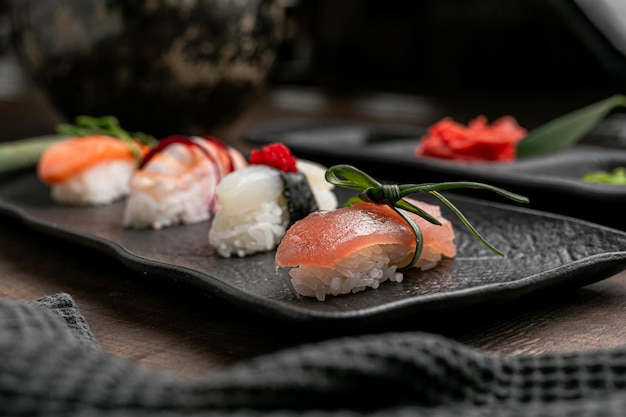 Side view of slices of shushi on black plate