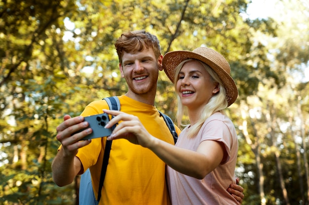 Foto coppia sorridente di vista laterale che prende selfie