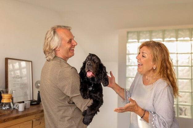 Photo side view smiley couple with dog