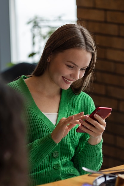 Photo side view smiley friends with smartphone