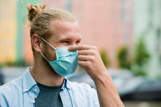 Photo side view of smiley man wearing face mask