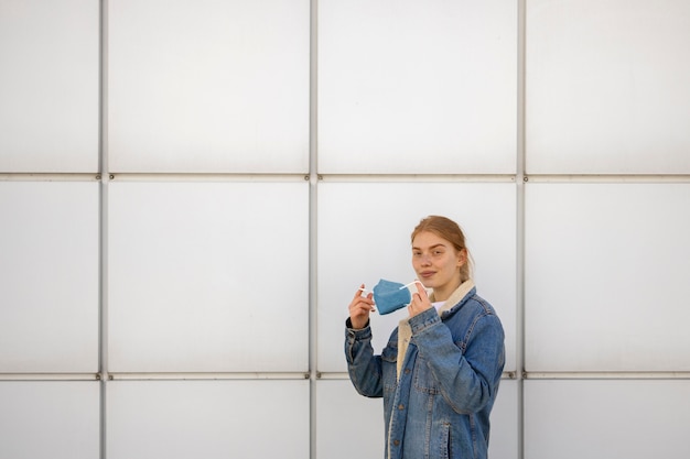 Side view smiley woman holding mask