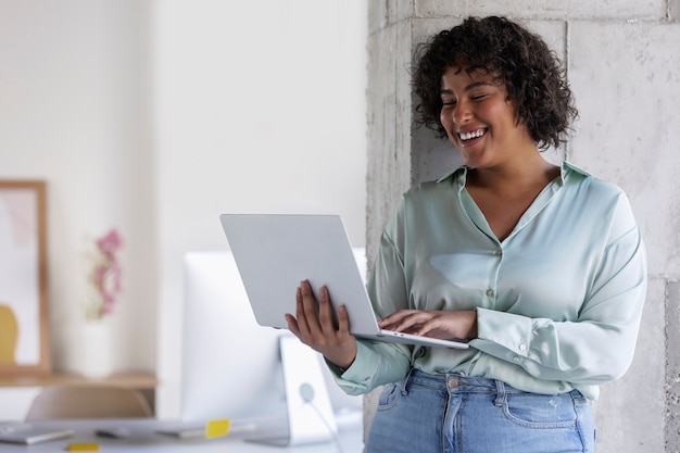 Foto donna sorridente di vista laterale con il computer portatile