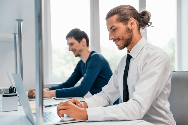 Side view smiling business man working on a laptop