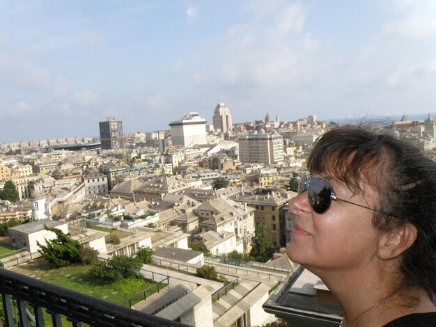 Side view of smiling woman looking away by buildings in city