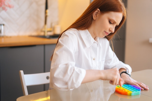 Side view of stressed young woman playing with fidget sensory toy to relieve stress to simple way to