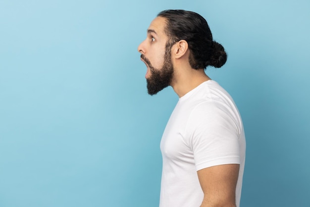 Vista laterale dell'uomo stupito sorpreso che guarda con espressione scioccata