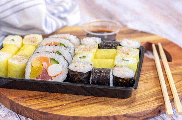 Side view sushi set with soy sauce  and chopsticks in wooden