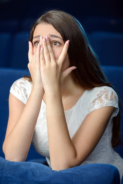 Side view of terrified young woman covering her face.