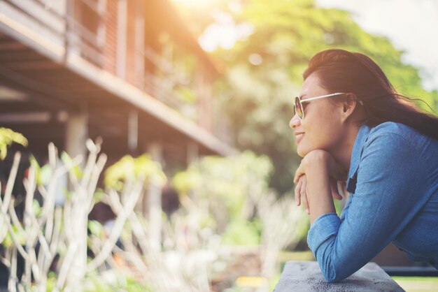 Photo side view of thoughtful woman leaning on railing outdoors