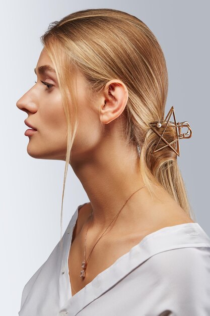 Side view of thoughtful young woman against gray background