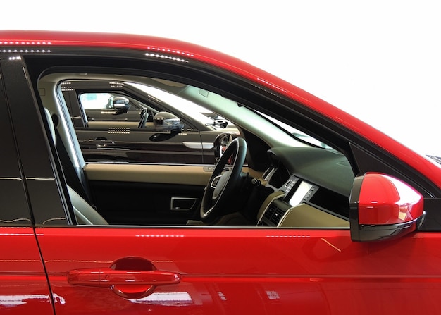 Side view through rolled window of vehicles interiors in dealership showroom