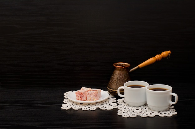 Side view of two cups of coffee on the lace napkins