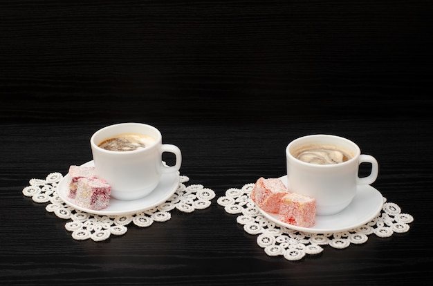 Side view of two mugs of coffee with ice-cream