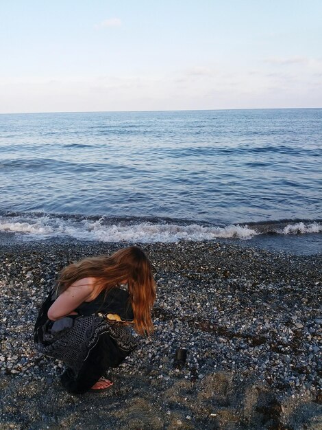 Foto side view van een vrouw die op het strand kruipt