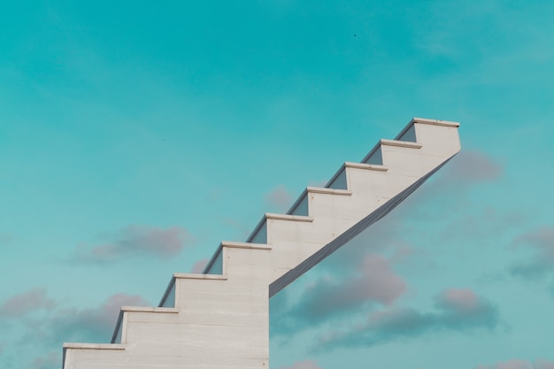 Photo side view of white wooden stairs with fantasy blue sky and clouds, in the background, goal, success concept