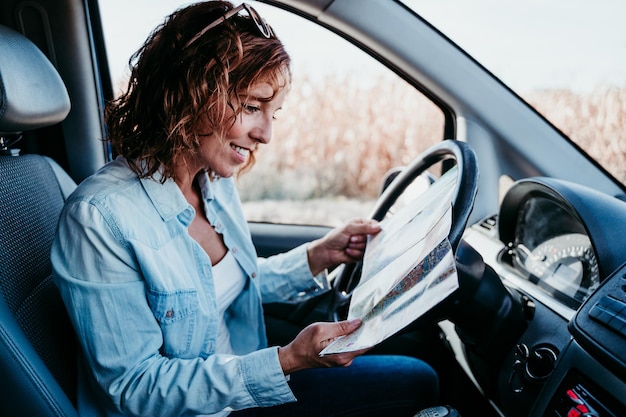 Foto vista laterale di una donna che analizza la mappa in una roulotte