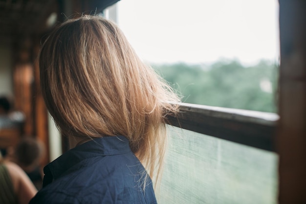 Foto vista laterale di una donna dalla finestra di un treno