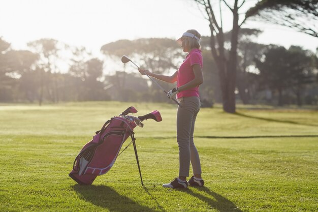 Side view of woman carrying golf club