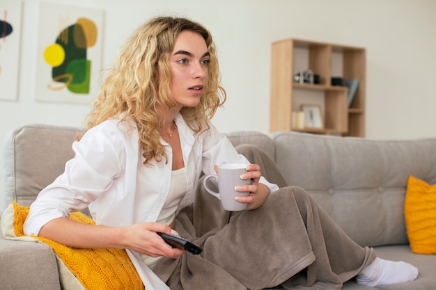 Photo side view woman on couch watching tv