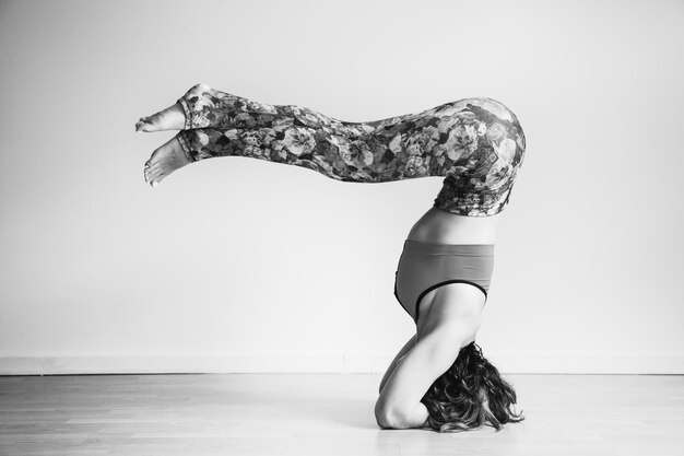 Photo side view of woman dancing against wall