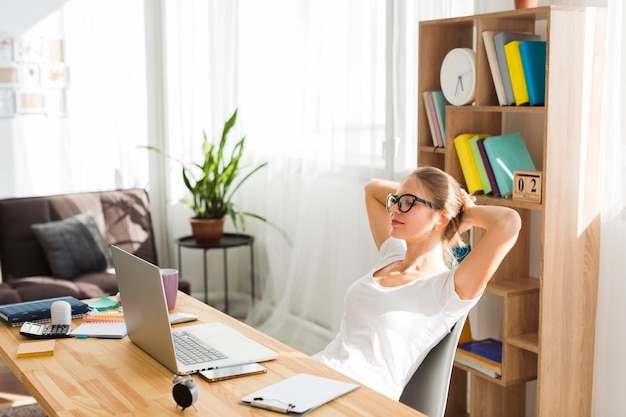 Vista laterale della donna allo scrittorio che lavora dalla casa