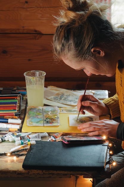 Foto vista laterale di una donna che disegna su carta.