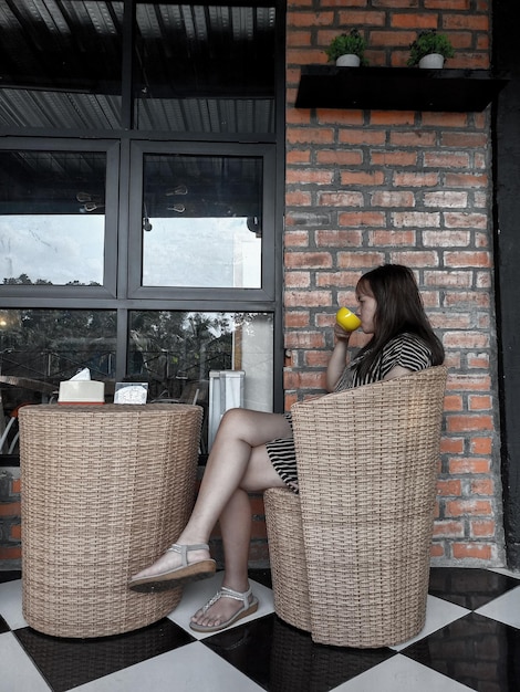 Foto vista laterale di una donna che beve caffè in un caffè