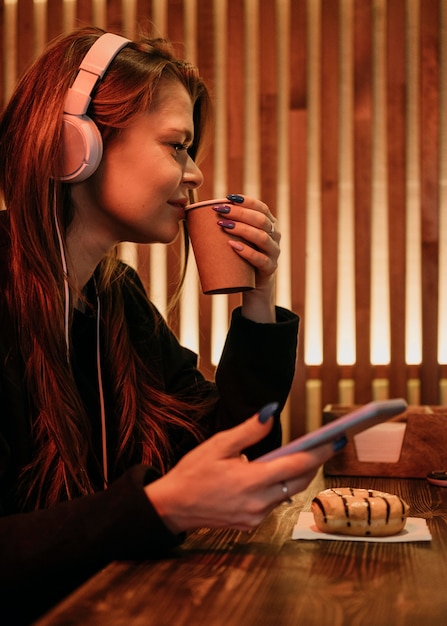 Foto donna di vista laterale che beve caffè