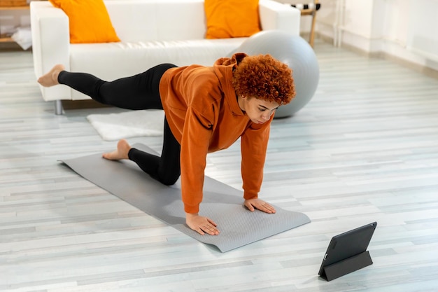 Side view of woman exercising on floor