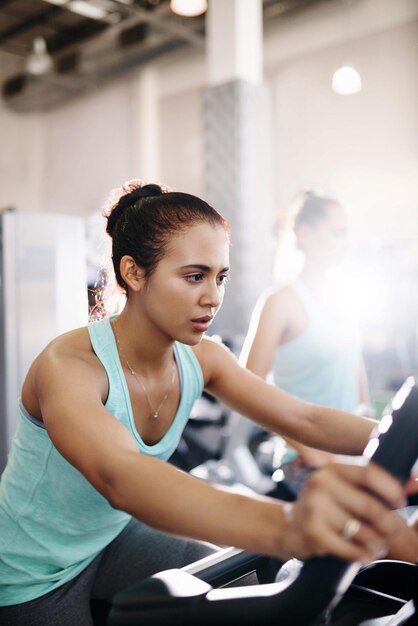 Photo side view of woman exercising in gym