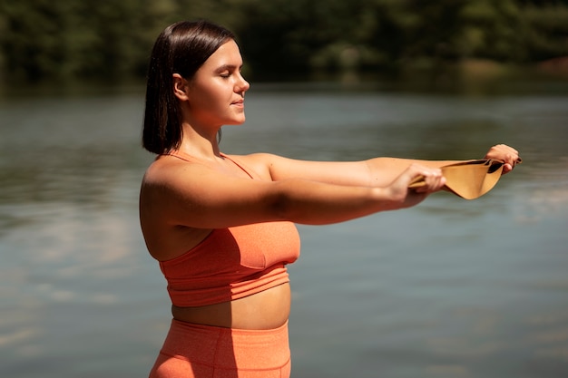 Photo side view woman exercising with elastic band