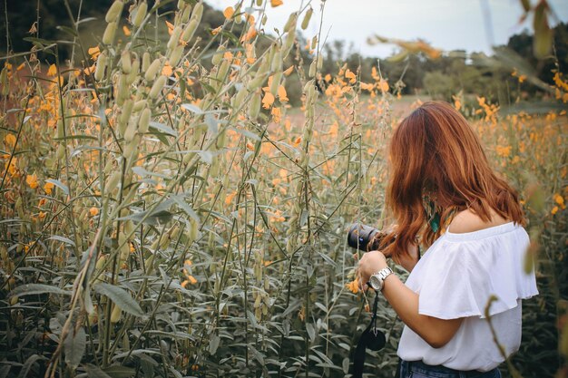 Photo side view of woman holding camera