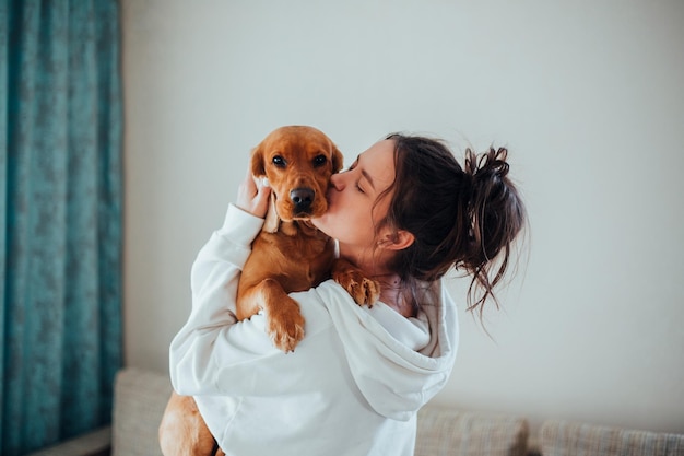 Photo side view of woman holding dog at home