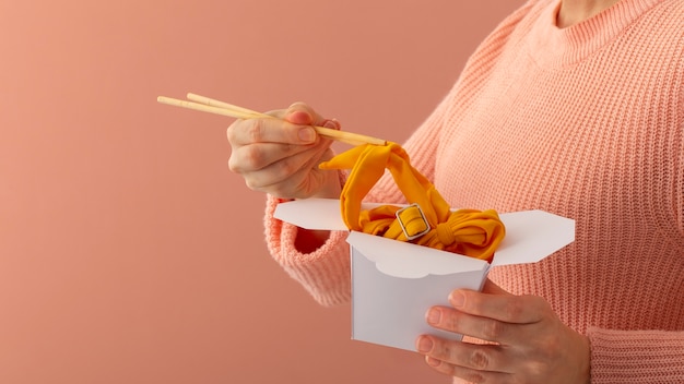 Foto donna con vista laterale che tiene il cibo fatto di vestiti