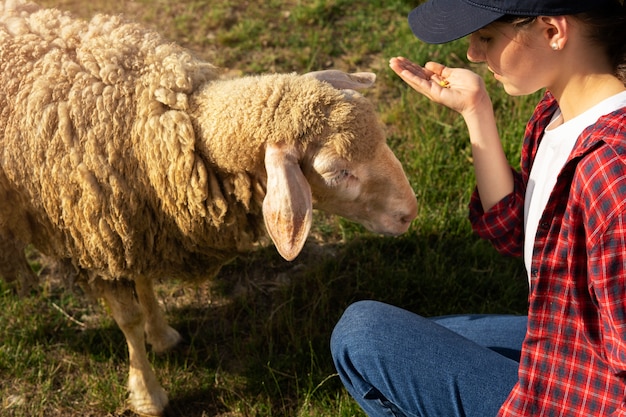 Photo side view woman holding sheep food