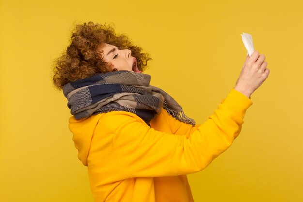 Side view of woman holding yellow camera