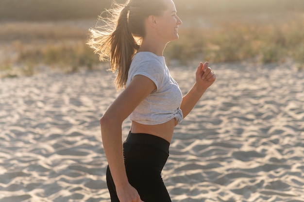 Side view of woman jogging on the beach