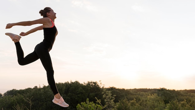 Photo side view woman jumping with copy space