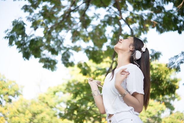 Photo side view of woman listening music through headphones