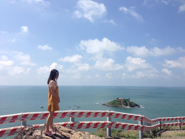 Photo side view of woman looking at sea against sky