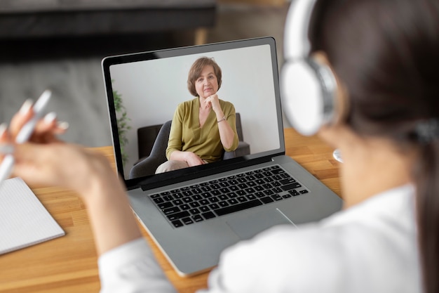 Foto vista laterale donna che effettua una videochiamata