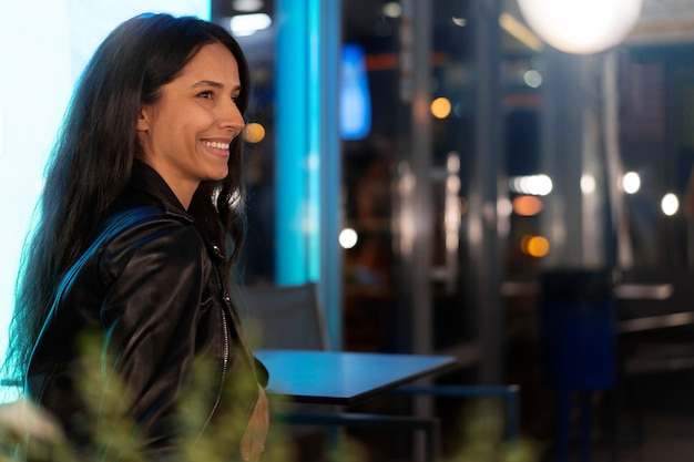 Photo side view of woman out in the city during the night