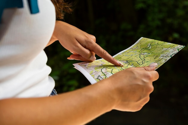 Vista laterale della donna all'aperto nella natura con mappa