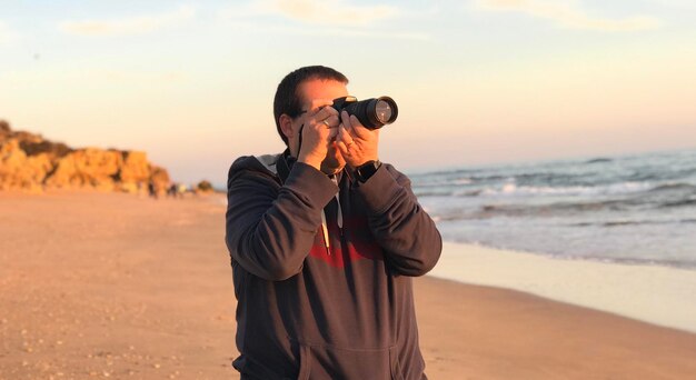 Photo side view of woman photographing at beach