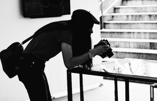 Photo side view of woman photographing while standing by table